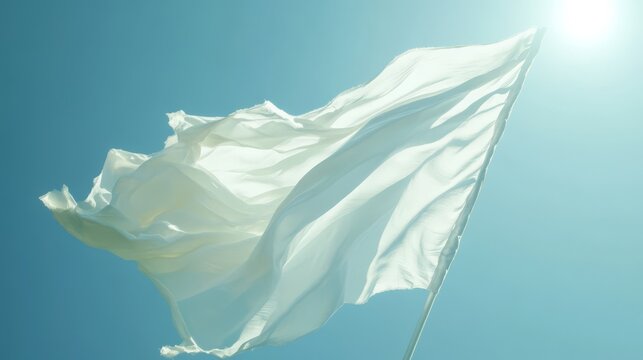 White flag waving in bright sunlight against a clear blue sky. - Powered by Adobe