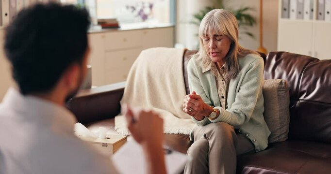 Old woman, therapy and speaking to doctor, remember trauma and history of grief in office. Stress, elderly person and consulting patient with depression at clinic, crisis and talk to psychologist