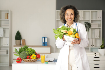 Mature female nutritionist with healthy food in office