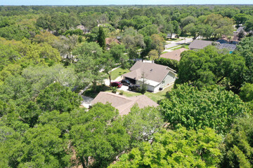 Aerial view of suburban middle class neighborhood homes nestled amongst trees, Port Orange, Florida, USA