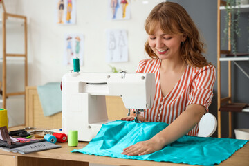 Female tailor sewing clothes at table in atelier