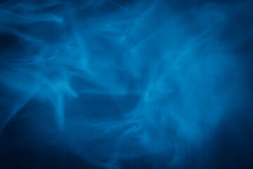 A close-up of soft, swirling blue smoke patterns creating an ethereal and dreamy abstract effect against a dark background