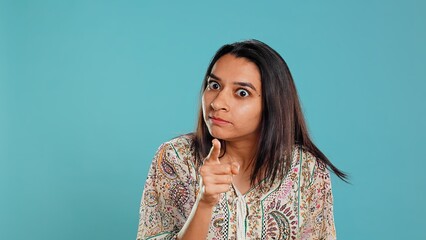 Irked indian woman fighting with boyfriend, doing scolding gesturing, isolated over studio...