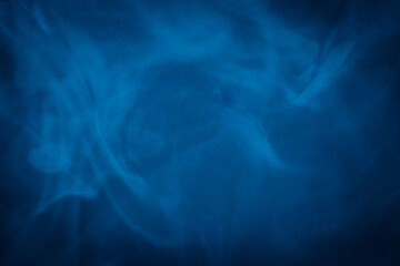 A close-up of soft, swirling blue smoke patterns creating an ethereal and dreamy abstract effect against a dark background