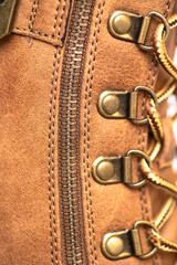 Brown leather boot with rivets, laces and zipper. Casual urban footwear. leather texture. Macro shot.