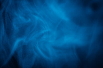 A close-up of soft, swirling blue smoke patterns creating an ethereal and dreamy abstract effect against a dark background