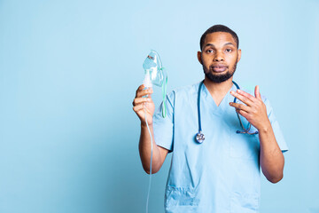 African american nurse presenting medical inhaler to help with aerosols intake, treatment for...