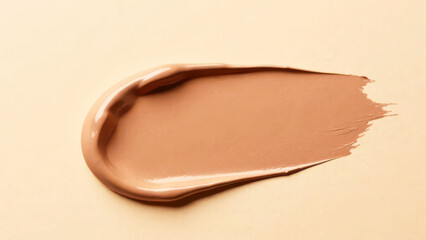 Fototapeta premium Smooth beige foundation swatch on neutral background, mocha mousse