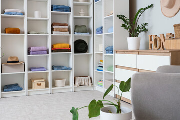 Big wardrobe with clothes and chest of drawers in dressing room