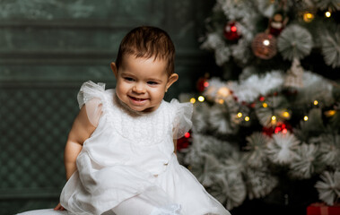 happy baby girl enjoying Christmas time by tree