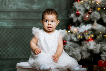 happy baby girl enjoying Christmas time by tree © Melinda Nagy