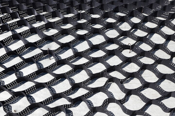 Polymer geogrid for filled with soil. Strengthening of sandy slopes with a geogrid