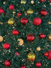 Detail of a Christmas Tree with Red and Gold Ornaments and Warm Lights