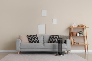 Interior of living room with sofa, blank frames and electric heater