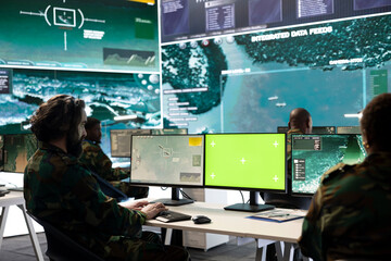 Army specialist operates on satellite radar surveillance and copy space screen, using real time...