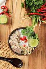 Top View Pho Bo Soup with Beef and Rice Noodles on a Wooden Background