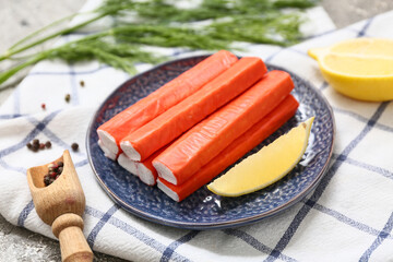 Plate with tasty crab sticks, cut lemon and dill on grey background, closeup © Pixel-Shot