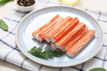 Plate with tasty crab sticks and dill on white background © Pixel-Shot