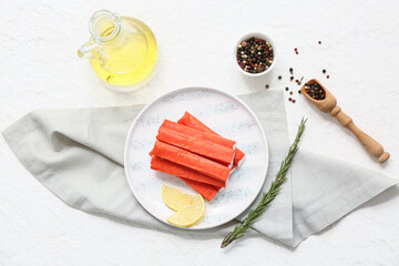 Plate with tasty crab sticks, slices of lemon and rosemary on white background © Pixel-Shot