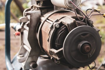 Close-up view of an industrial motor during maintenance in an outdoor workshop setting