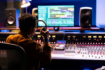 Audio expert leveling sound on a mixer control panel board, professional music studio concept....