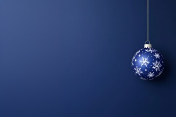 Fototapeta premium Elegant blue christmas ornament with white snowflake design on dark blue background