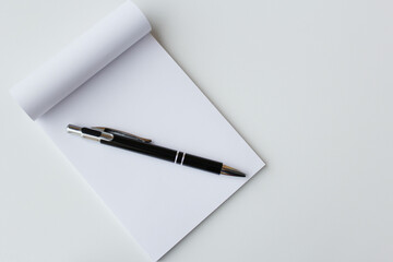 Black pen and white paper notepad banner background with copy space. Office supplies, school stationery, education, taking notes, writing concept.	