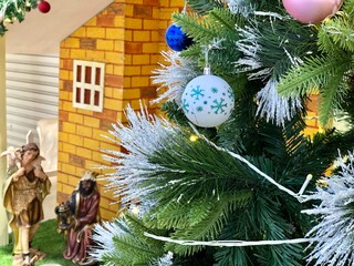 Christmas tree decorations with nativity scene background.