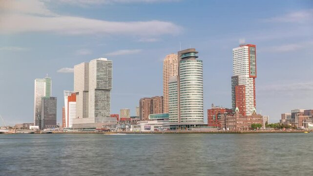 Rotterdam skyline timelapse from Nieuwe Maas River bank to Wilhelminapier and Kop van Zuid. Modern skyscrapers, ship terminal and waterfront in this redeveloped former harbor area with boats passing