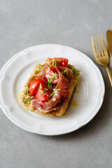 Belgian potato waffles served with ham, tomatoes and herbs with cutlery on a concrete background. Healthy breakfast, savory waffles