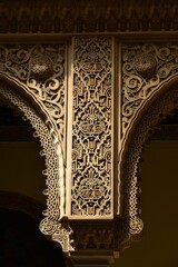 Detail of extravagantly decorated top part of a column sided by spandrels in neo Arabesque style...