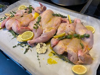 raw chicken fillet on grey background with lemon garlic rosemary thyme