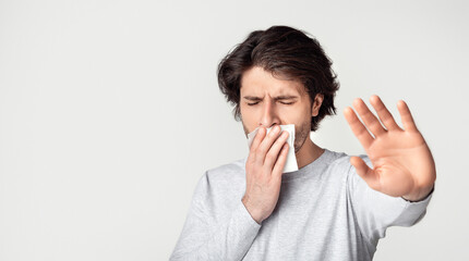 Afraid of dentist. Upset man with toothache shut his mouth with napkin