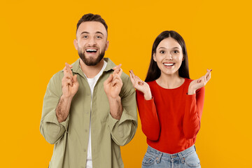 A young couple expresses joy and affection with smiles and gestures. They stand close together against a vibrant backdrop, radiating happiness and connection.