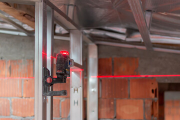 Using a laser to mark the outlines on the floor and transfer them to the walls and ceiling for accurate construction measurement and alignment. Modern tools for construction