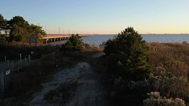 sunrise drone shot over woods and transition to bridge over water