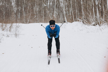Focused cross-country skier on a scenic training trail in the woods