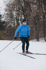 Solo cross-country skier in a winter forest during a training session