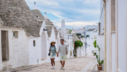 Couple strolling hand-in-hand through the charming streets of Puglia, Italy on a serene afternoon
