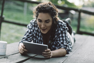 Fototapeta premium Young woman using digital tablet outdoors in a farm