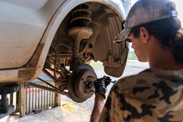A skilled mechanic is working on a vehicles suspension system for optimal performance and safety