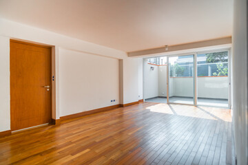 Sala de departamento con piso de melamina, con mampara y vista a patio iluminado