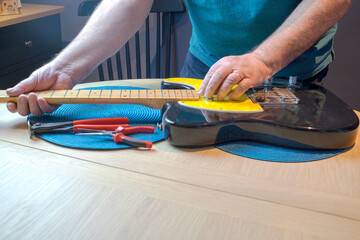 stringing an old electric guitar and tuning up.