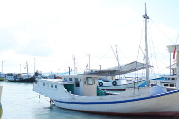 Fototapeta premium Quiet Beach with Traditional Boat and Clear Blue Waters