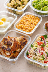 Healthy meal prep with grilled chicken, eggs, lentils, roasted vegetables, nuts and salad