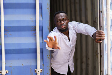 Anti human trafficking concept. A man is escaping out the cage or container.