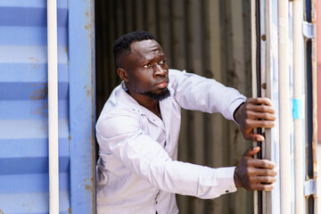 Anti human trafficking concept. A man is escaping out the cage or container.