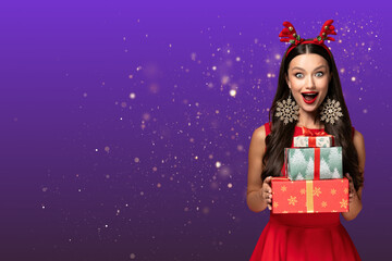 Christmas woman, in surprise with gifts, on purple background, with place for text.