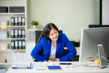 Asian businesswoman office worker suffering from neck pain after had a long day at her office desk.