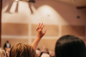 Woman with hand raised in church service, worship